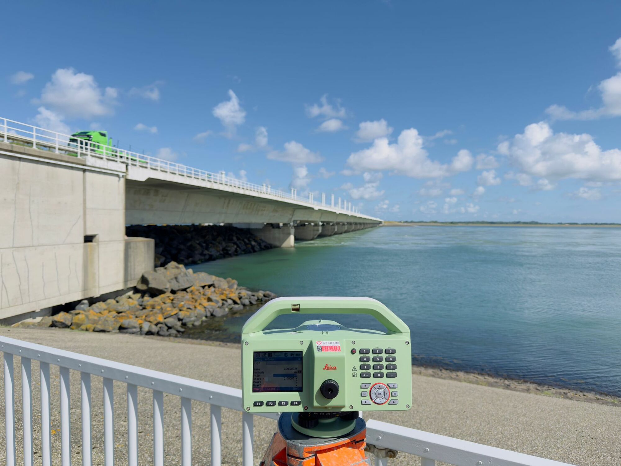 Totalstation opgesteld op een brug over het water tijdens een controlemeting