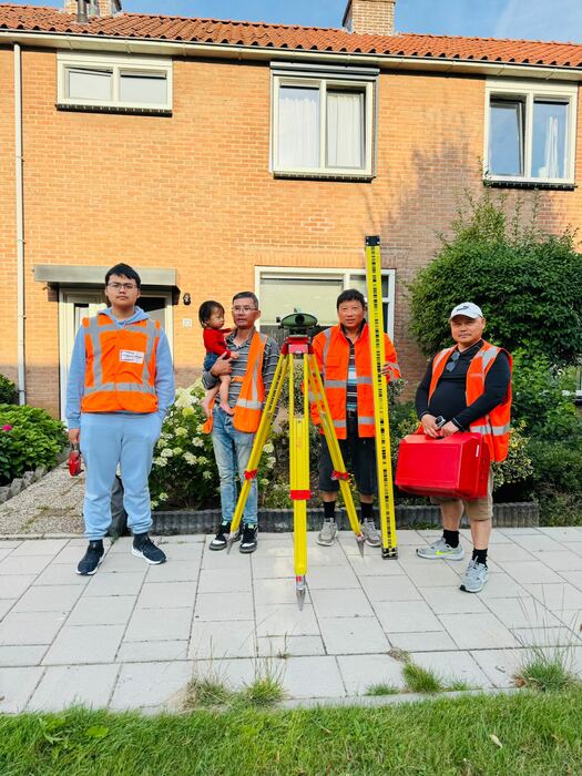 Meetploeg met instrumenten voor een rij woningen